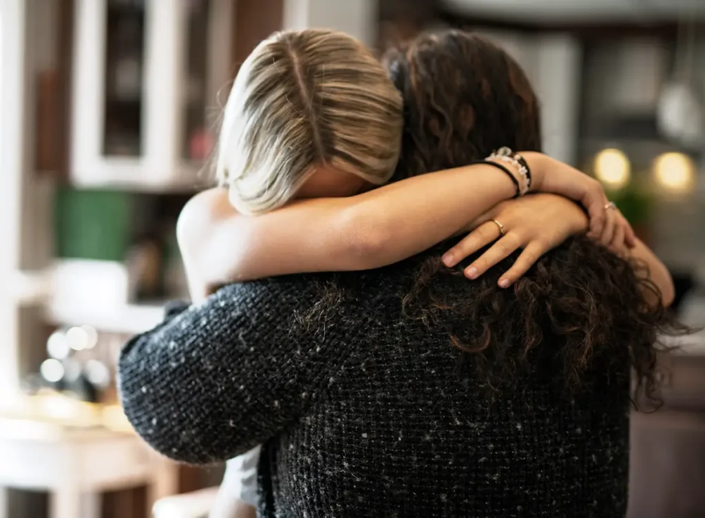 Daughter hugging mother due to juvenile legal issues.